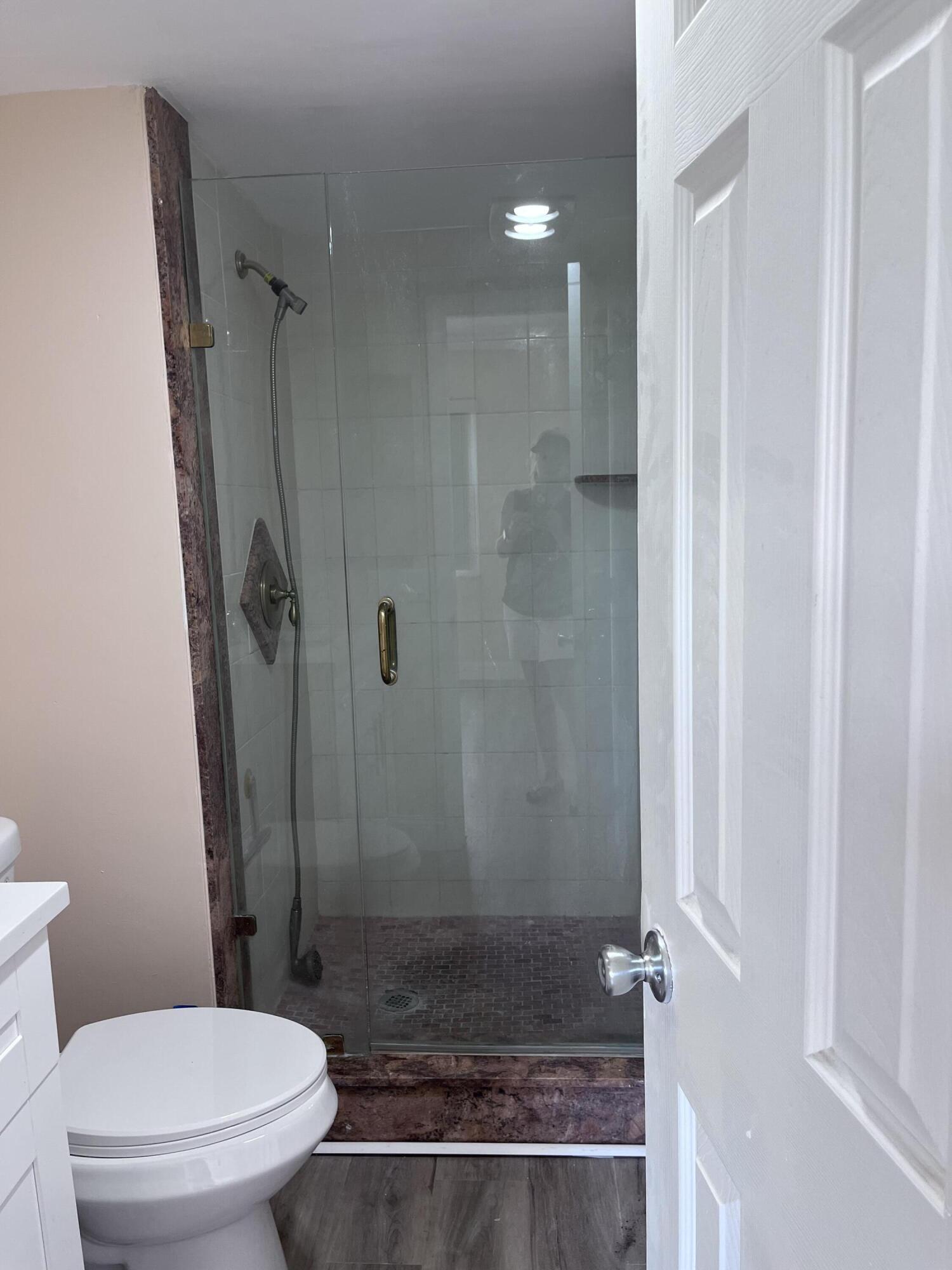 251 South Golf Boulevard, Unit 294 Pompano Beach, FL 33064 - Photo 19 of 36 a bathroom with a granite countertop shower a toilet and a sink