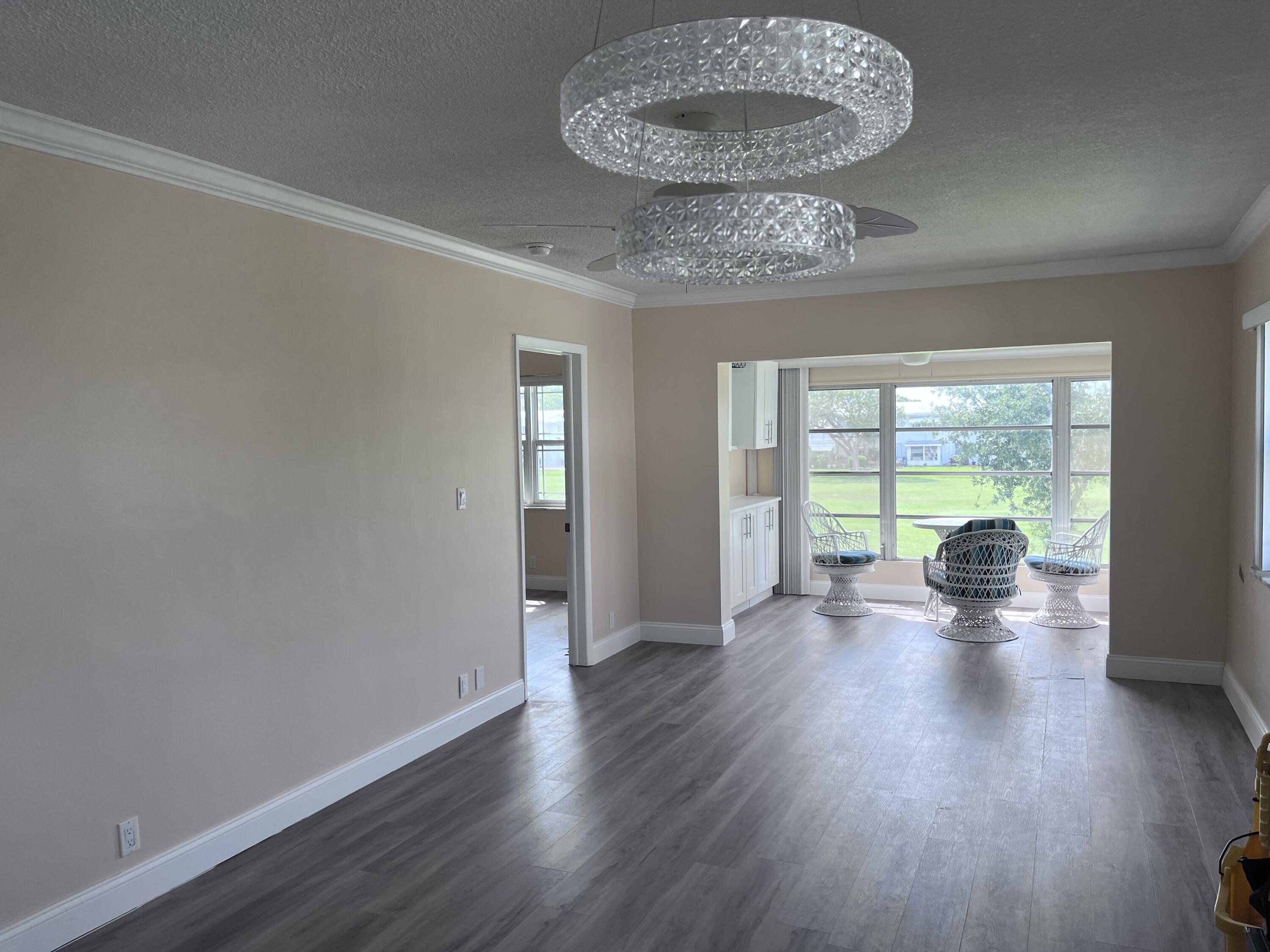 251 South Golf Boulevard, Unit 294 Pompano Beach, FL 33064 - Photo 26 of 36 a view of an empty room with wooden floor and a window