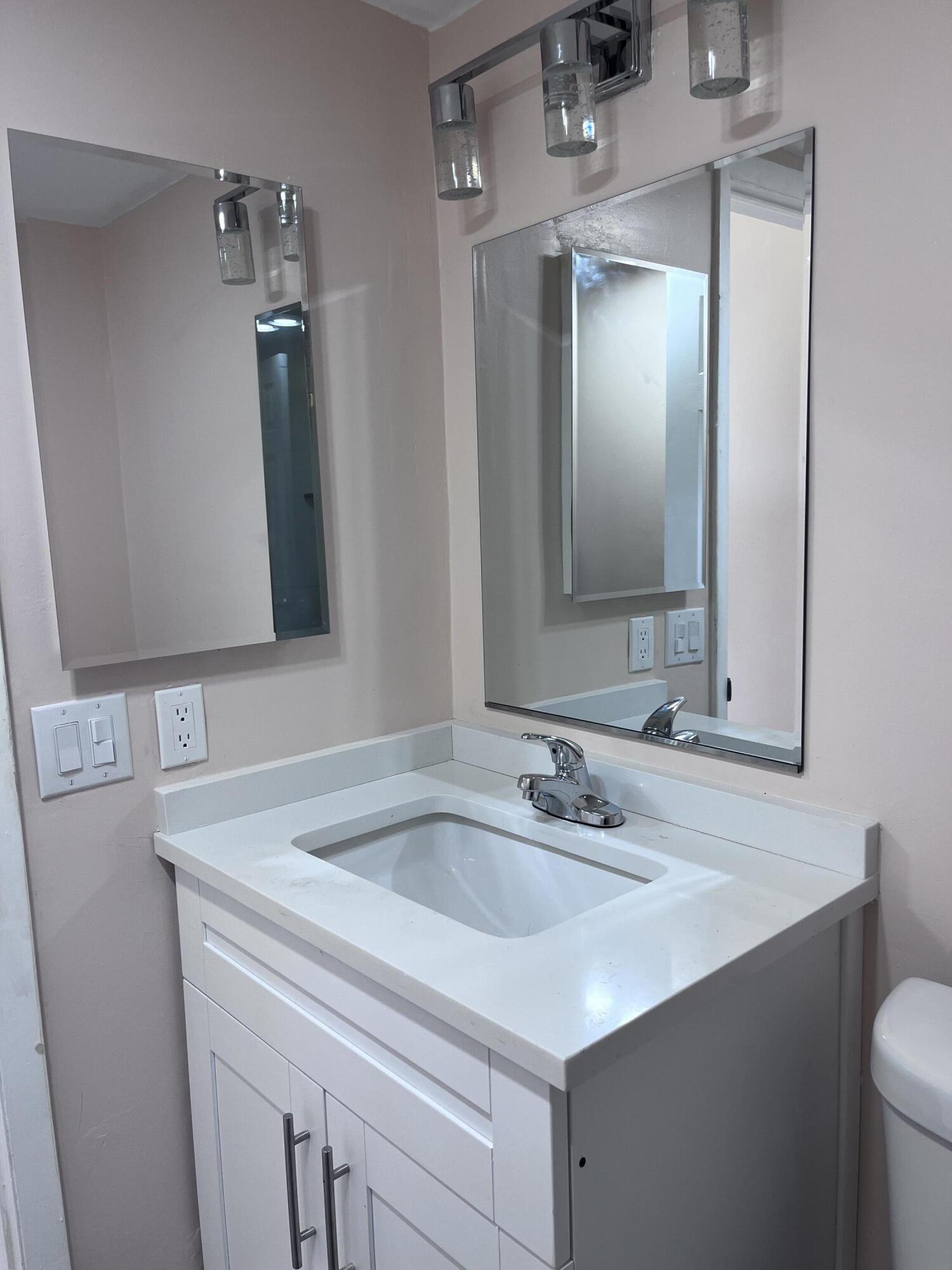 251 South Golf Boulevard, Unit 294 Pompano Beach, FL 33064 - Photo 30 of 36 a bathroom with a sink and a mirror