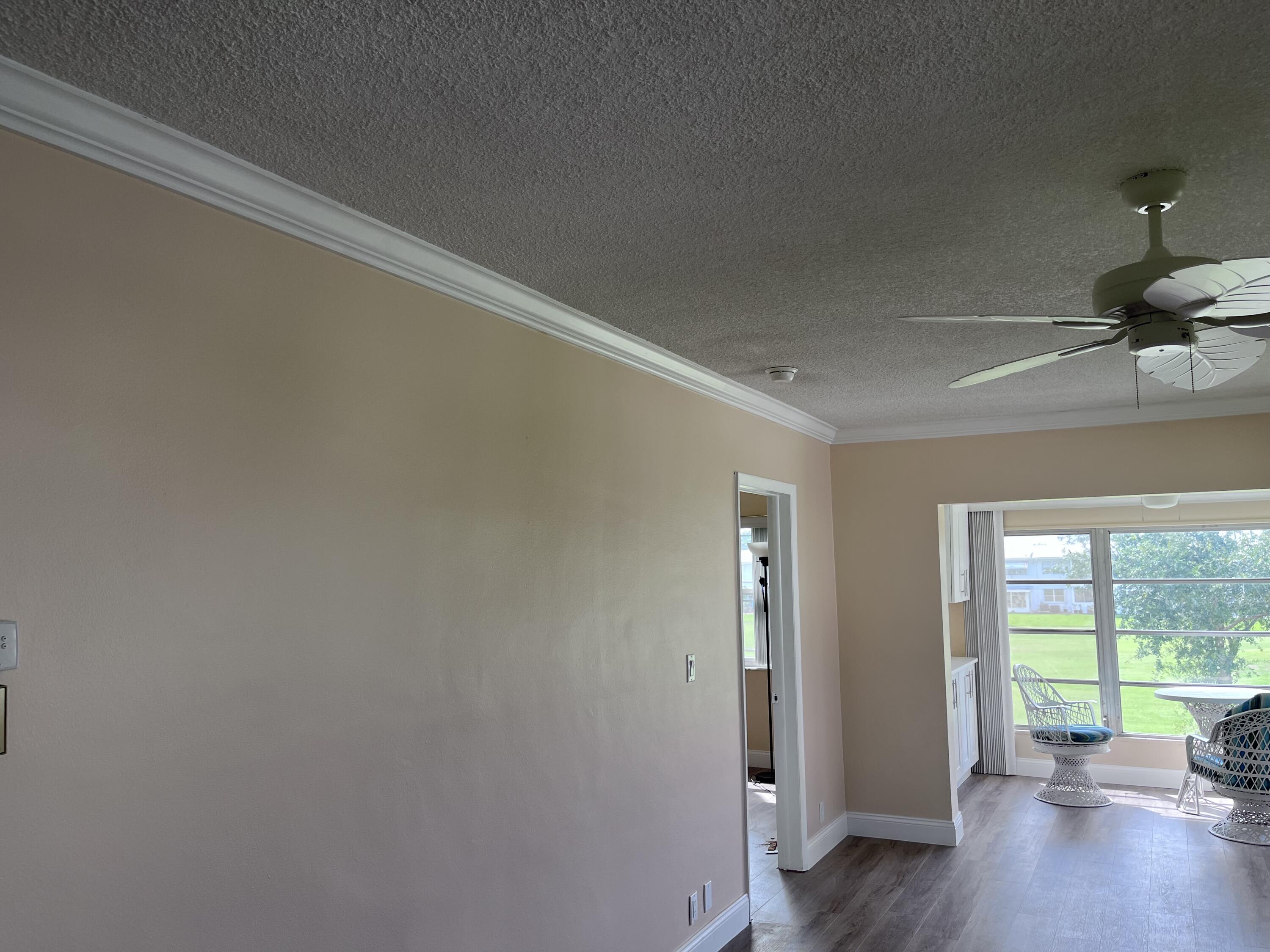 251 South Golf Boulevard, Unit 294 Pompano Beach, FL 33064 - Photo 32 of 36 a view of an empty room with wooden floor and a window