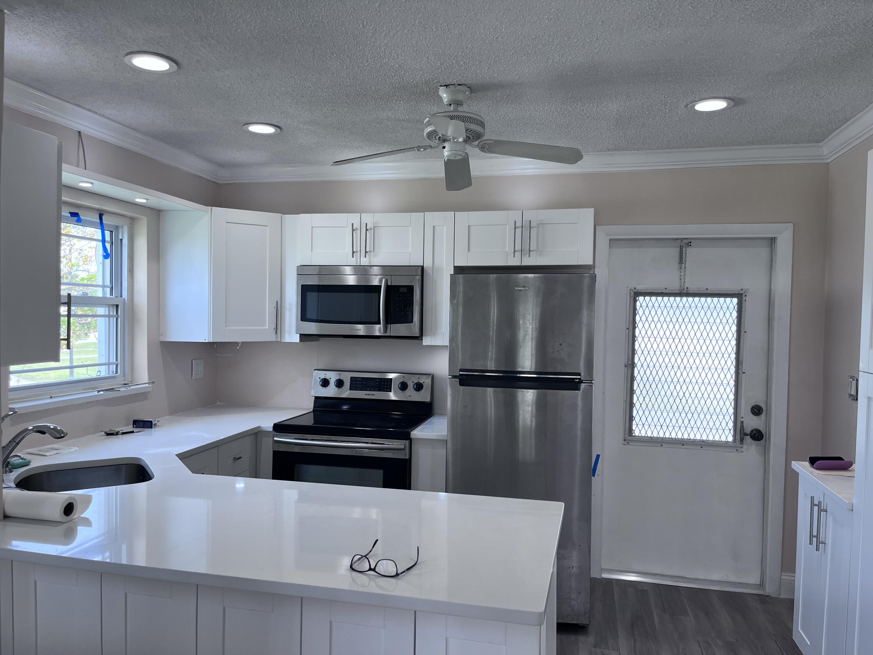 251 South Golf Boulevard, Unit 294 Pompano Beach, FL 33064 - Photo 33 of 36 a kitchen with stainless steel appliances a refrigerator a sink a stove a microwave a counter space and cabinets