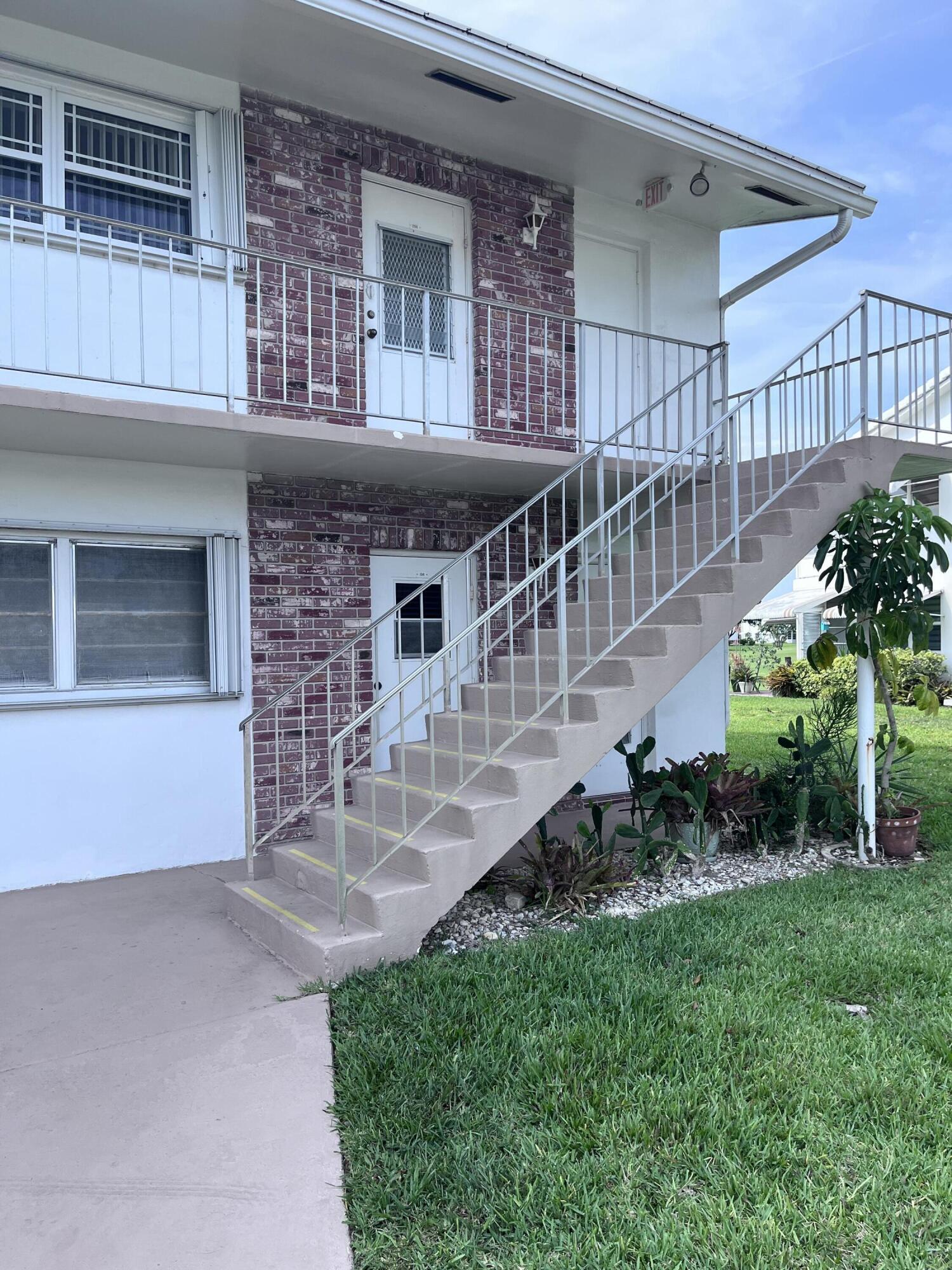 251 South Golf Boulevard, Unit 294 Pompano Beach, FL 33064 - Photo 36 of 36 a view of a house with brick walls and a yard in front of it