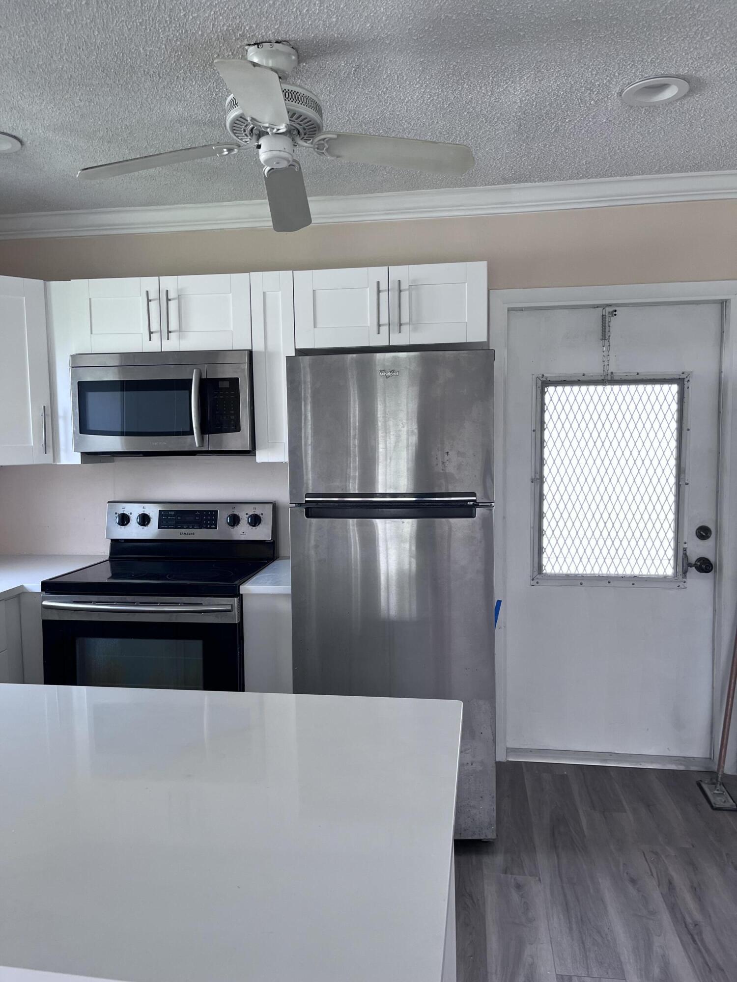 251 South Golf Boulevard, Unit 294 Pompano Beach, FL 33064 - Photo 6 of 36 a view of kitchen with sink microwave and refrigerator