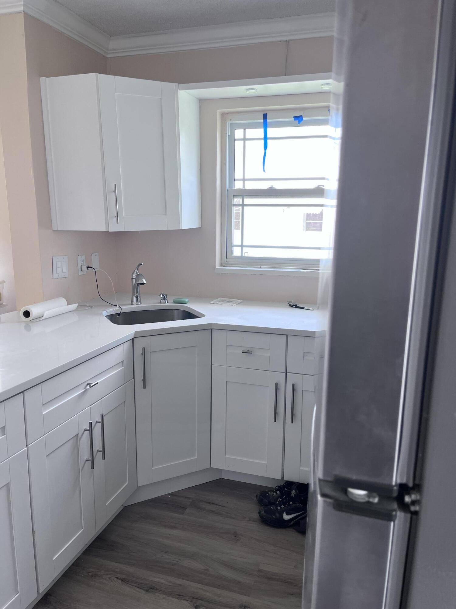 251 South Golf Boulevard, Unit 294 Pompano Beach, FL 33064 - Photo 7 of 36 a kitchen with a sink cabinets appliances and a window
