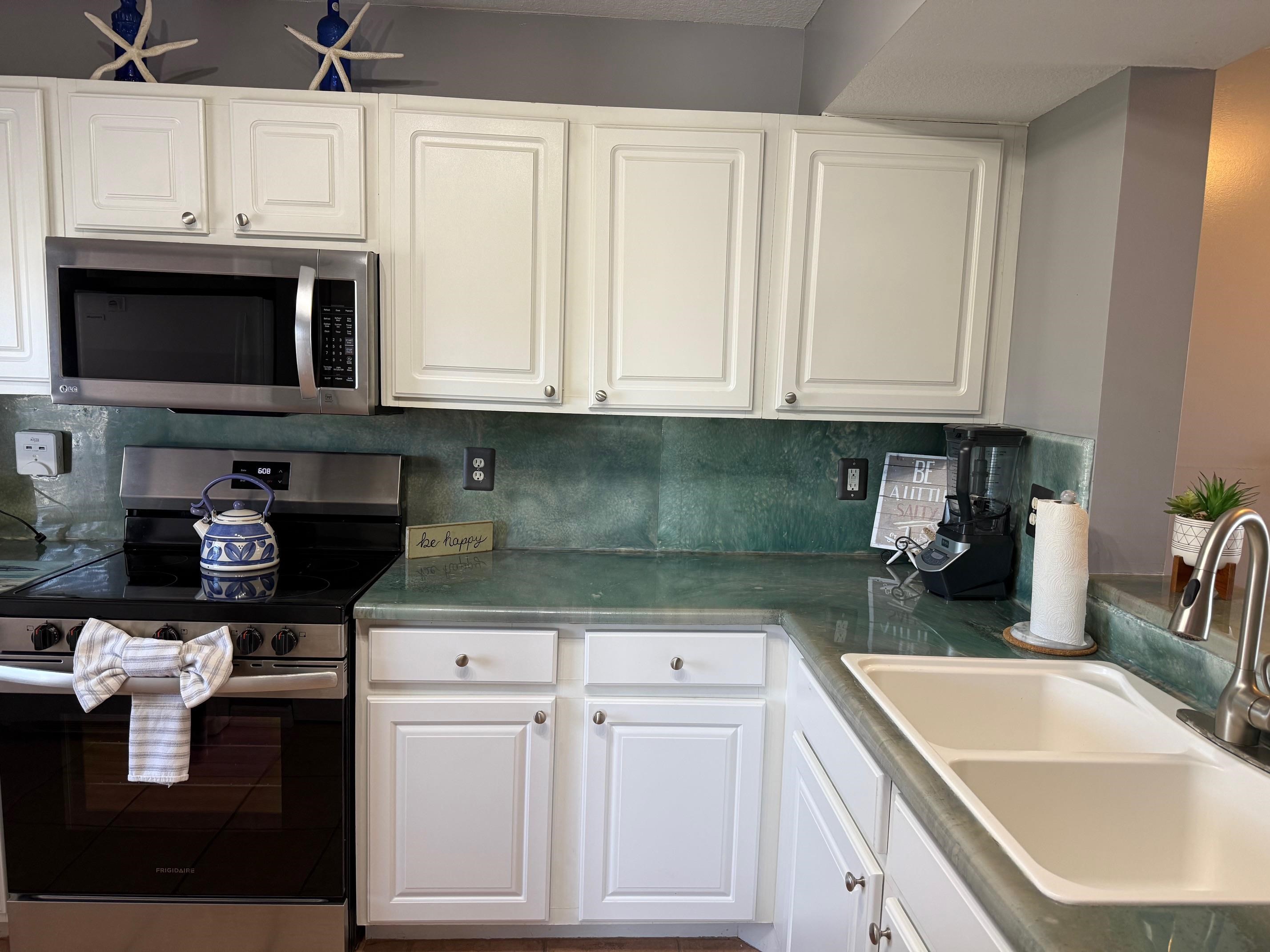 210 16th Street St. Augustine Beach, FL 32080 - Photo 7 of 21 a kitchen with stainless steel appliances granite countertop a sink stove and cabinets