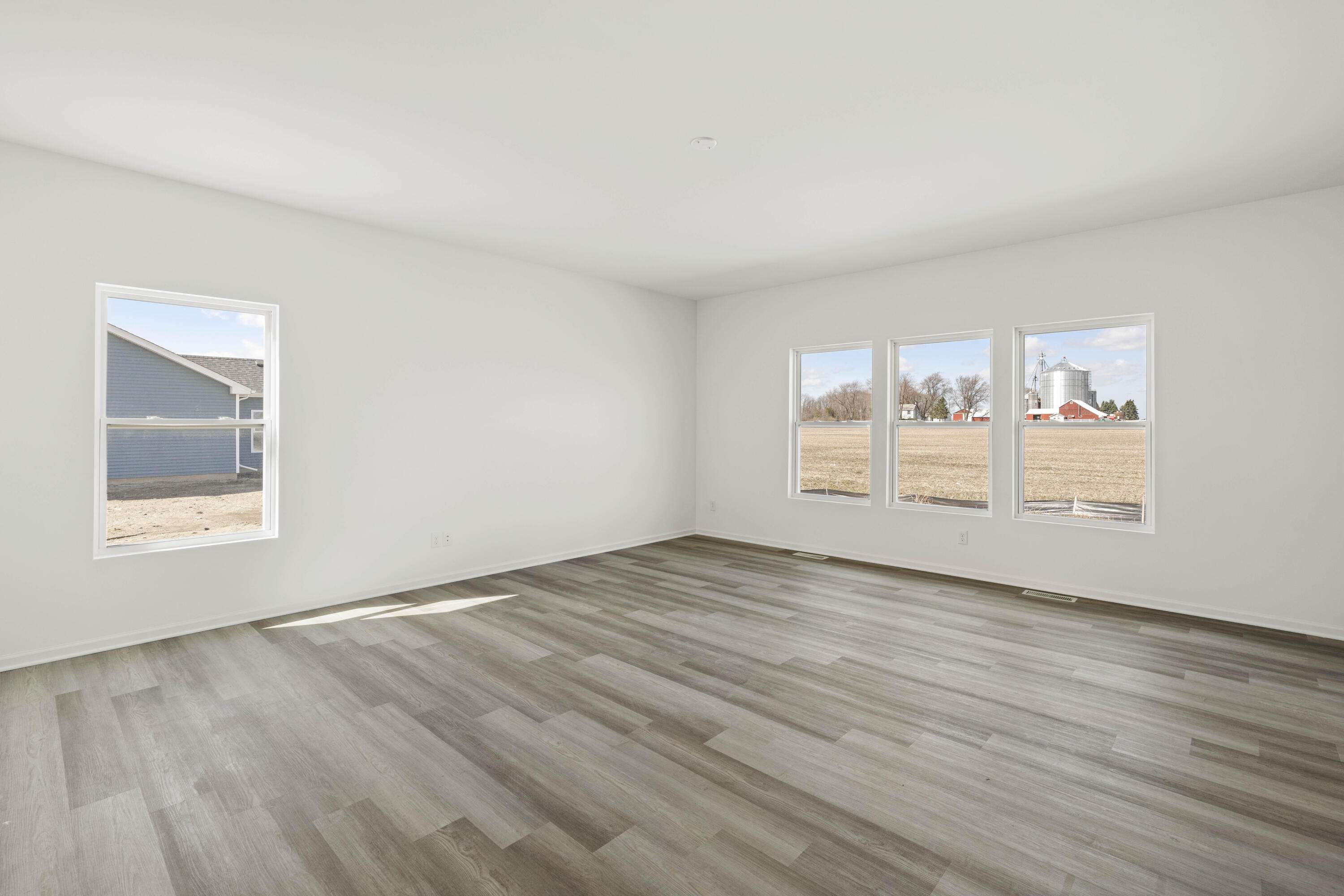 6711 East 103rd Avenue Crown Point, IN 46307 - Photo 6 of 13 a view of an empty room with wooden floor and a window