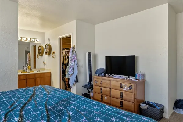 a bedroom with a bed and flat screen tv
