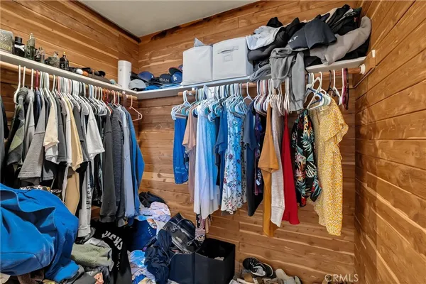 a view of walk in closet with clothes and shoes