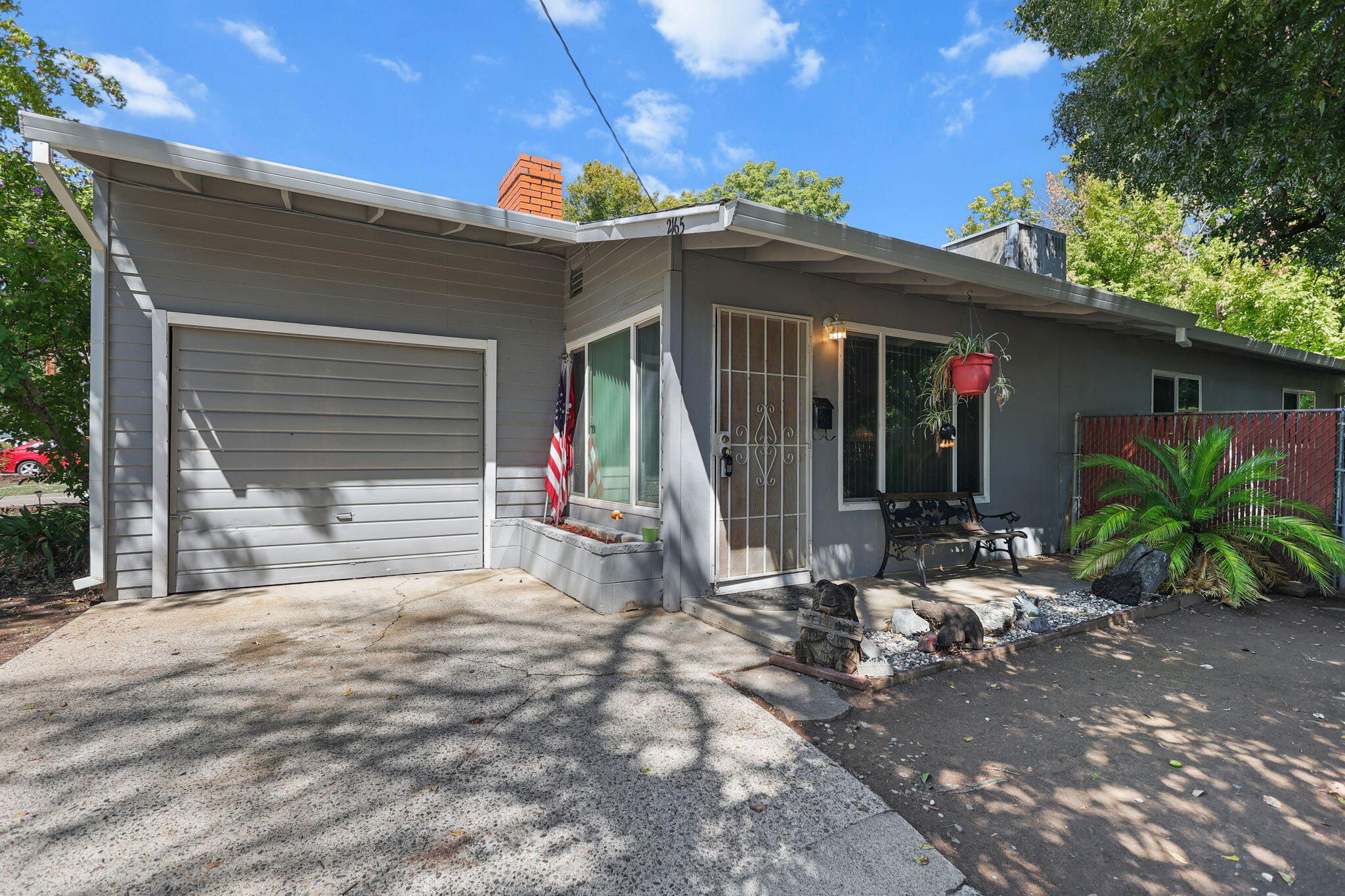 2165 Paris Avenue Redding, CA 96001 - Photo 1 of 22 a view of a house with a small yard and floor to ceiling window and potted plants