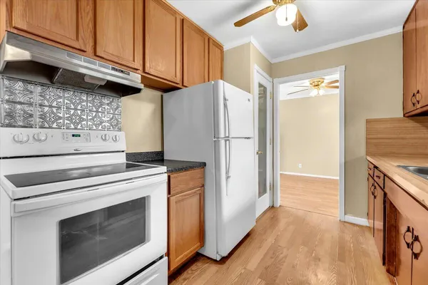 a kitchen with granite countertop a stove and a refrigerator