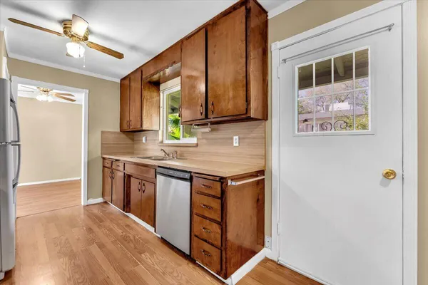 a kitchen with stainless steel appliances granite countertop a refrigerator a stove and a sink with wooden floor