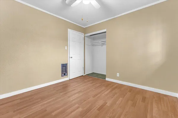 a view of an empty room with wooden floor
