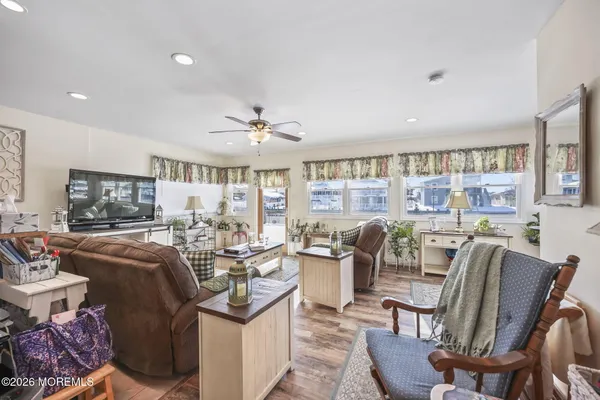 a living room with furniture a flat screen tv and a large window