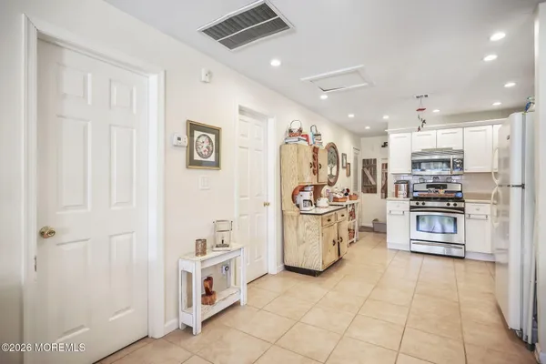 a kitchen with white cabinets and refrigerator