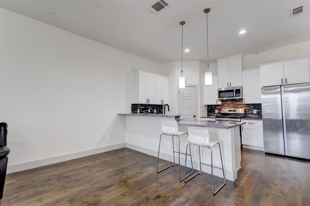 6043 Rivendell Drive Frisco, TX 75035 - Photo 7 of 38 a kitchen with stainless steel appliances granite countertop a refrigerator a sink a stove and white cabinets