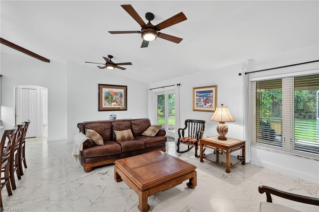 1741 17th Street Southwest Naples, FL 34117 - Photo 22 of 50 Living area featuring light satin finish porcelain tile flooring, arched walkways, lofted ceiling, and ceiling fan