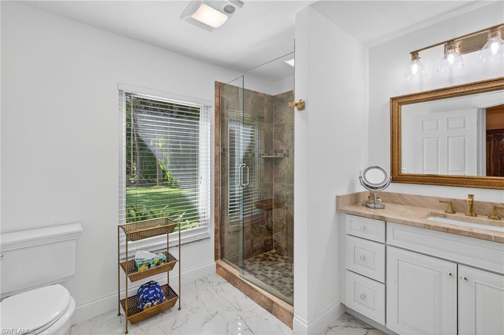 1741 17th Street Southwest Naples, FL 34117 - Photo 27 of 50 Bathroom featuring a shower stall, vanity, and light satin finish porcelain tile flooring