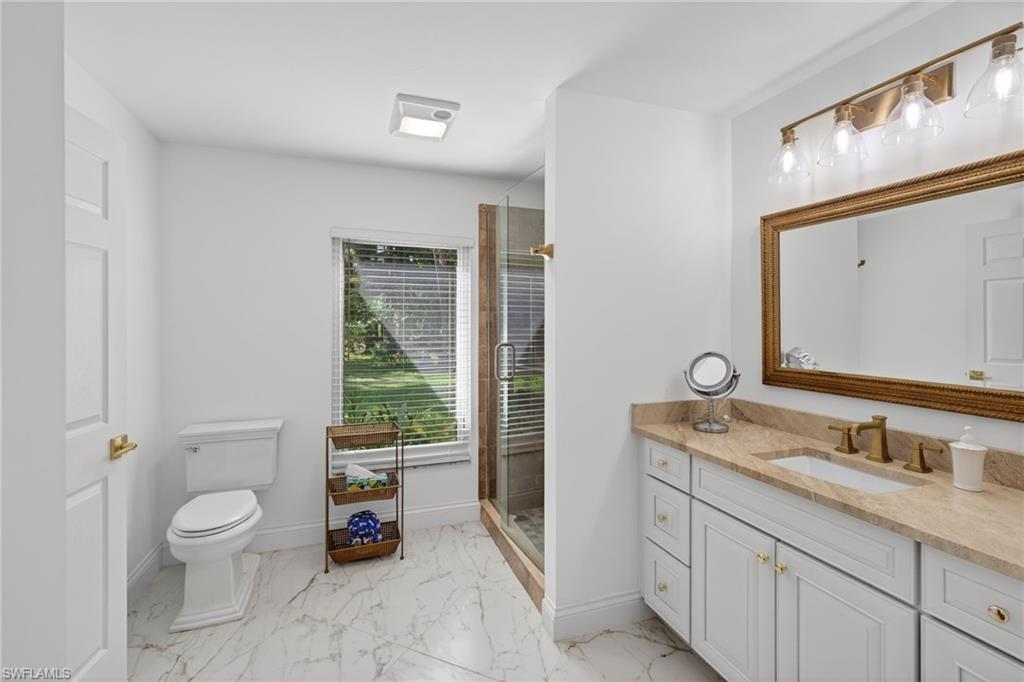 1741 17th Street Southwest Naples, FL 34117 - Photo 29 of 50 Full bathroom featuring vanity, a shower stall, and light satin finish porcelain tile flooring