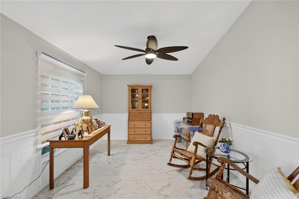1741 17th Street Southwest Naples, FL 34117 - Photo 33 of 50 Living area with a decorative wall, a wainscoted wall, light satin finish porcelain tile flooring, and a ceiling fan