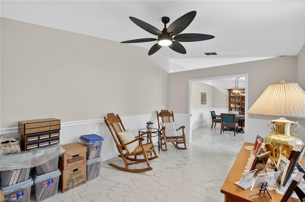 1741 17th Street Southwest Naples, FL 34117 - Photo 34 of 50 Sitting room featuring light satin finish porcelain tile flooring, wainscoting, a chandelier, and lofted ceiling