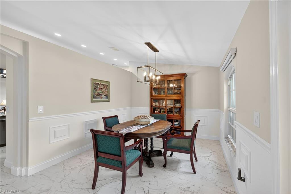 1741 17th Street Southwest Naples, FL 34117 - Photo 9 of 50 Dining room with a wainscoted wall, light satin finish porcelain tile flooring, recessed lighting, a decorative wall, and a chandelier