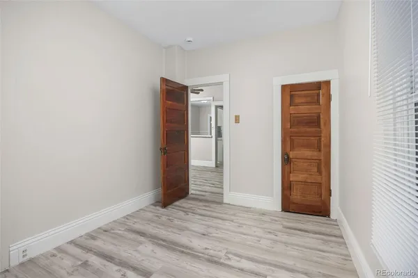 a view of an empty room with wooden floor