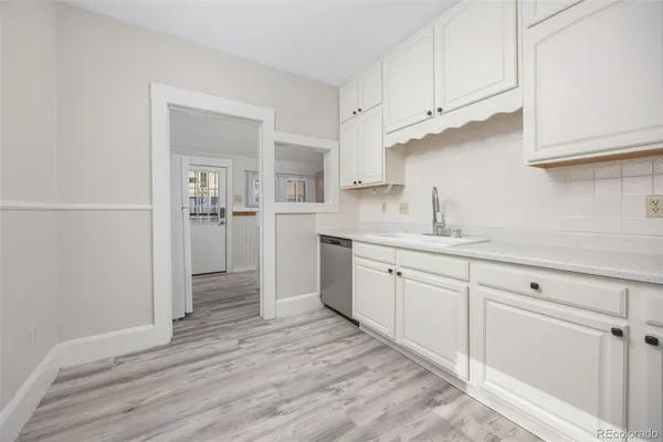 a kitchen with cabinets and wooden floor