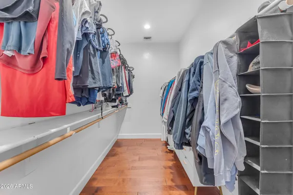 a view of walk in closet with clothes and shoes