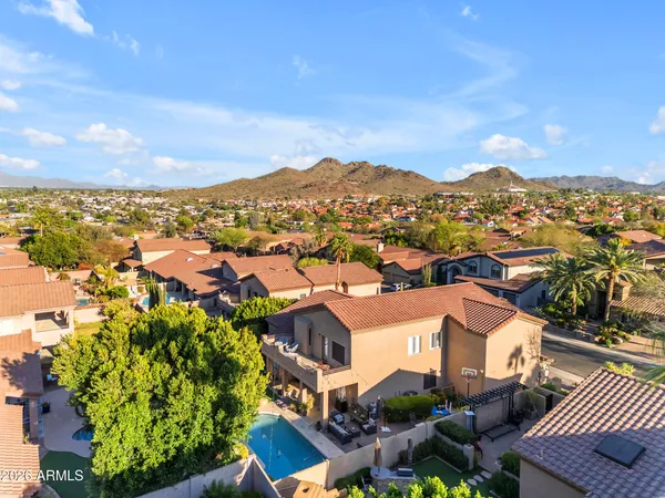 an aerial view of residential houses with outdoor space and parking