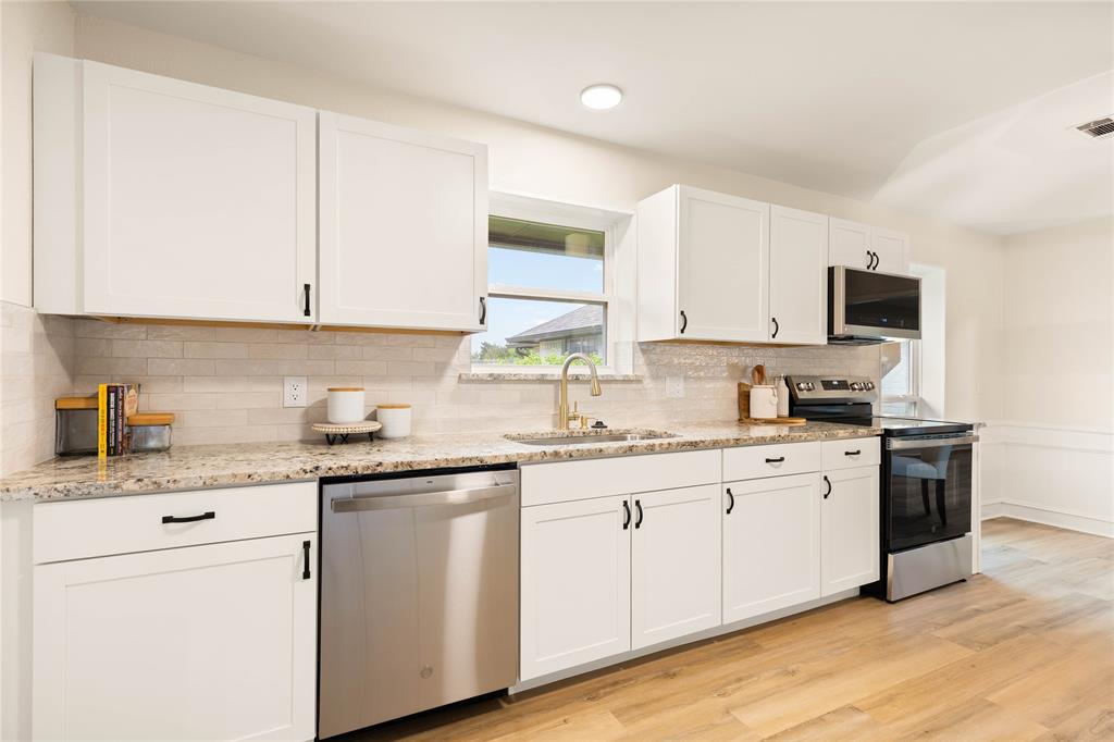 2850 Oak Tree Lane Midlothian, TX 76065 - Photo 6 of 40 a kitchen with granite countertop white cabinets and white appliances