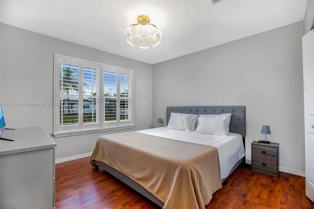 a large bed sitting in a bedroom next to a window