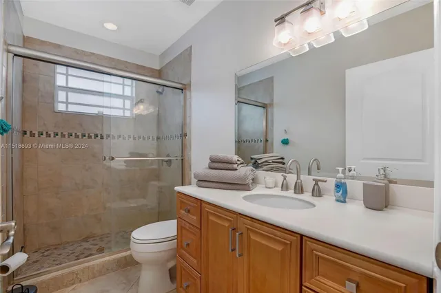 a bathroom with a double vanity sink mirror and toilet