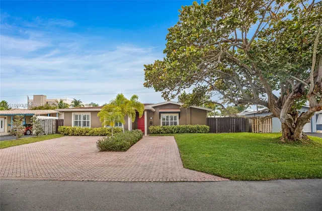 a front view of a house with a yard and trees