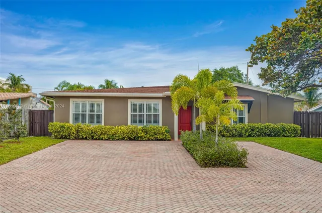 a front view of a house with a yard and potted plants