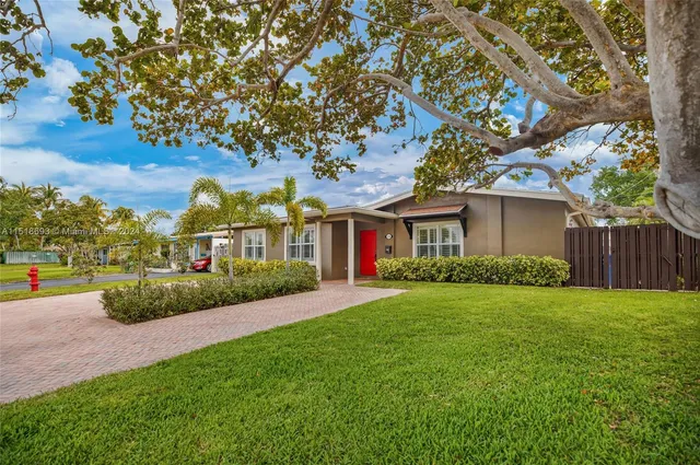 a view of a big yard in front of a house with large tree