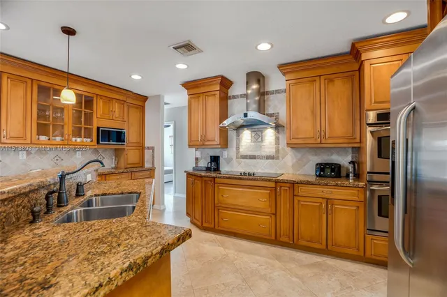 a kitchen with granite countertop a sink stainless steel appliances and cabinets