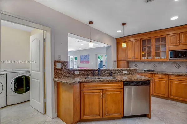 a kitchen with stainless steel appliances granite countertop a stove a sink and a refrigerator