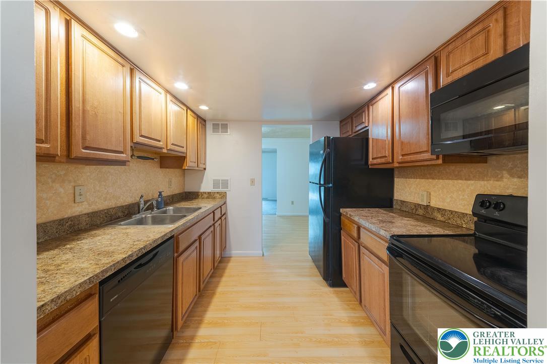 7528 Buttercup Road Lower Macungie Township, PA 18062 - Photo 8 of 30 a kitchen with stainless steel appliances granite countertop a stove a sink and a refrigerator
