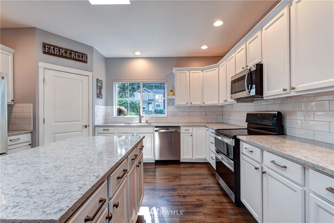 214 159th Street Southeast Bothell, WA 98012 - Photo 5 of 26 a kitchen with stainless steel appliances granite countertop a sink stove and refrigerator