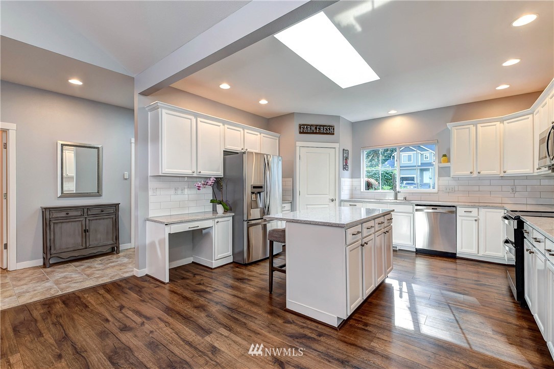 214 159th Street Southeast Bothell, WA 98012 - Photo 6 of 26 a kitchen with a sink cabinets wooden floor and stainless steel appliances