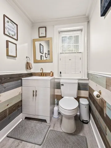 a living room with wooden floor pool table and chairs