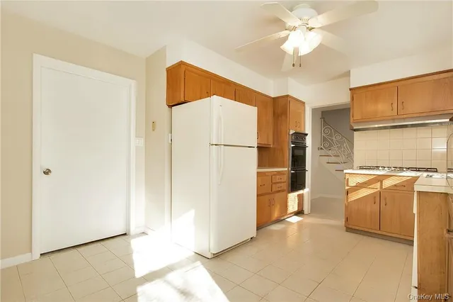 a view of a kitchen with a refrigerator and a stove top oven