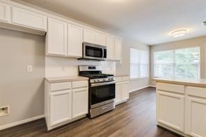 3210 Candlepine Drive Spring, TX 77388 - Photo 11 of 27 a kitchen with stainless steel appliances white cabinets a sink and a stove
