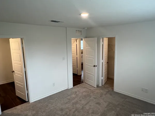 an empty room with closet and wooden door