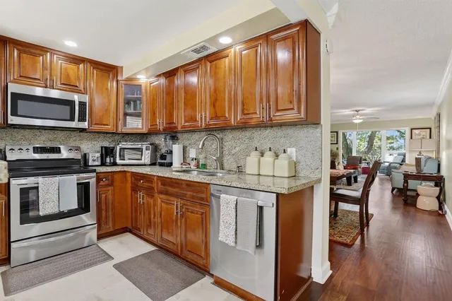 a kitchen with stainless steel appliances granite countertop a stove sink microwave and cabinets