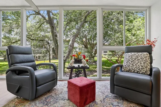 a living room with furniture and a floor to ceiling window