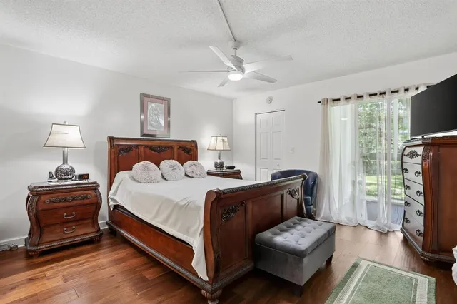 a bedroom with a bed couch and a flat tv screen