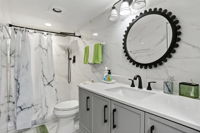 a bathroom with a sink a toilet and a mirror