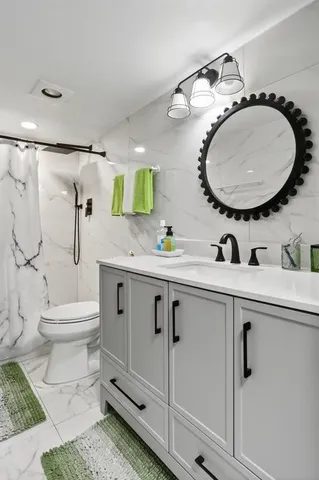 a bathroom with a toilet a sink and mirror