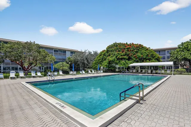 a view of a swimming pool with a patio and a yard